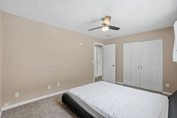 a bedroom with a bed and ceiling fan