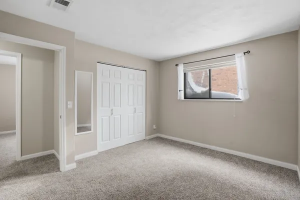 an empty room with windows and closet