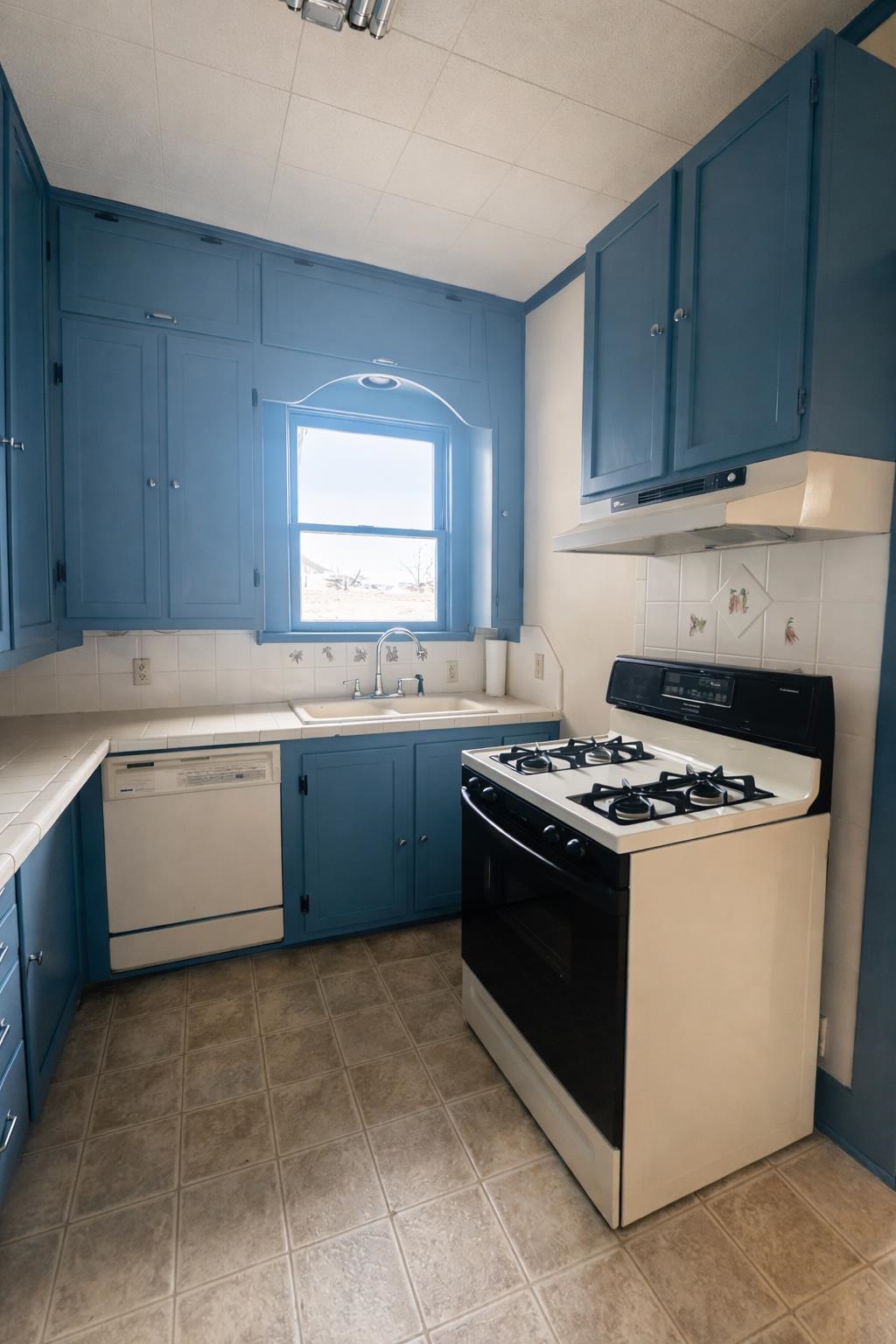 206 East Sandstone Street Llano, TX 78643 - Photo 4 of 16 a kitchen with a stove sink and cabinets