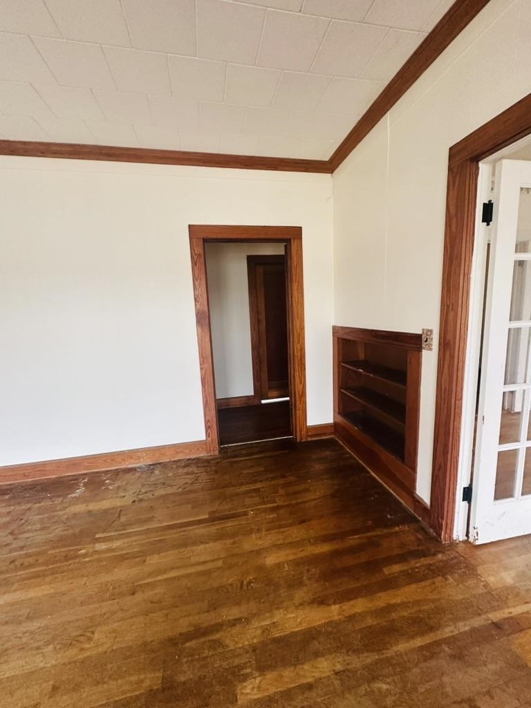 206 East Sandstone Street Llano, TX 78643 - Photo 9 of 16 a view of an empty room with wooden floor and a window