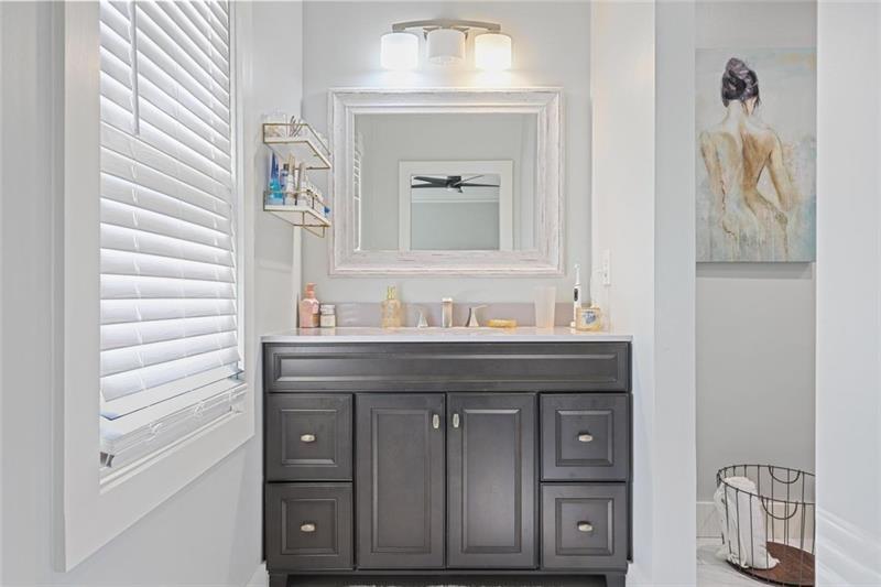 1665 Cunningham Road Southwest Marietta, GA 30008 - Photo 16 of 36 a bathroom with a granite countertop sink and a mirror