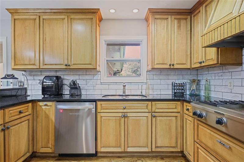 1665 Cunningham Road Southwest Marietta, GA 30008 - Photo 5 of 36 a kitchen with granite countertop a sink cabinets and stainless steel appliances