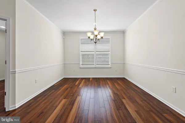 a view of a room with wooden floor and chandelier