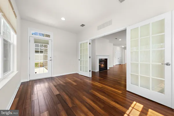 an empty room with wooden floor and windows
