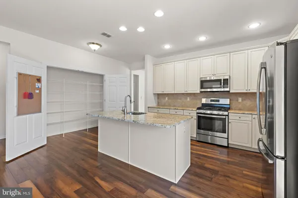 a kitchen with stainless steel appliances a refrigerator stove microwave and cabinets