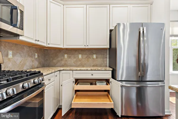 a kitchen with stainless steel appliances a refrigerator and a stove top oven