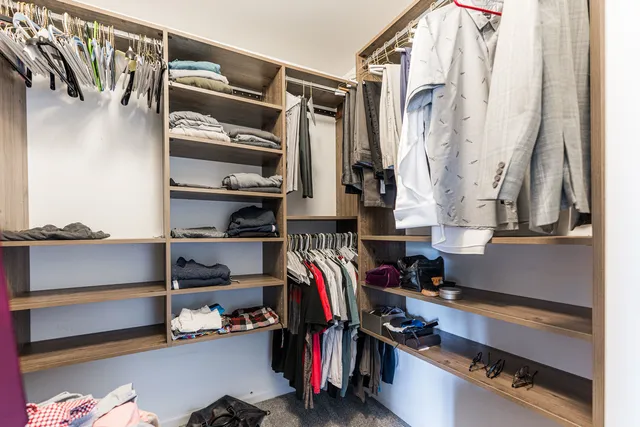 a view of walk in closet with clothes and shoes