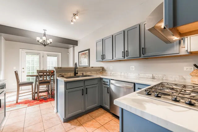 a kitchen with a sink a stove cabinets and dining table