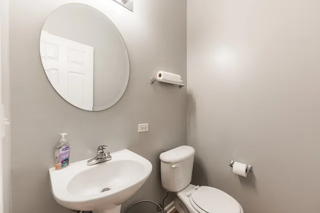 a bathroom with a toilet a sink and a mirror