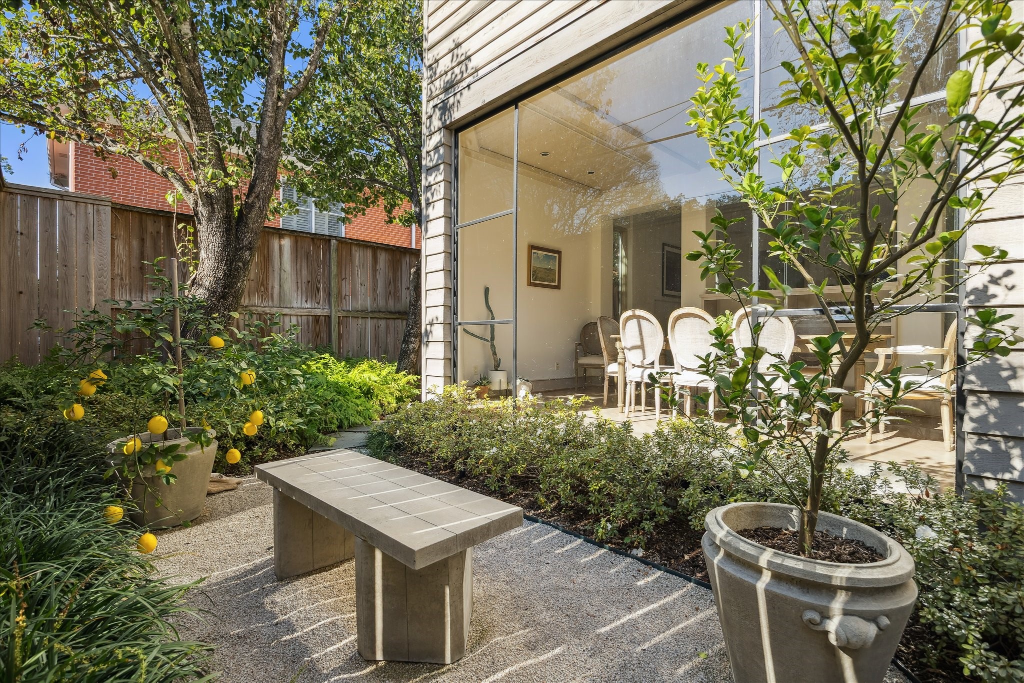 1807 Albans Road Houston, TX 77005 - Photo 31 of 39 a backyard of a house with table and chairs potted plants and large tree
