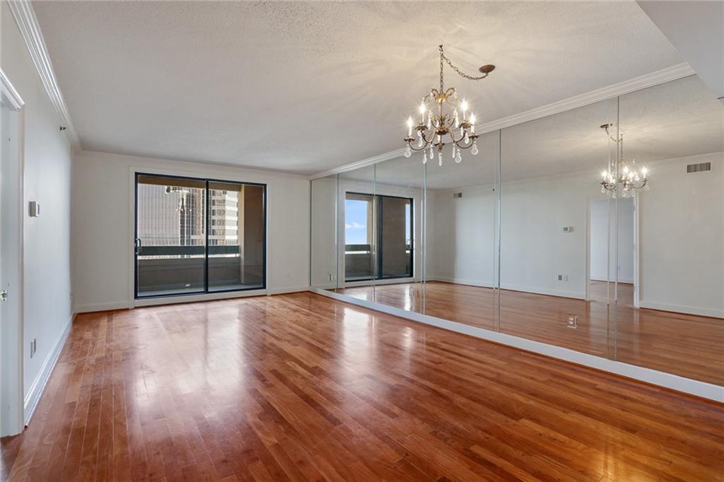 a view of a livingroom with wooden floor and chandelier