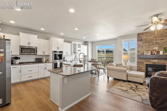 a kitchen with white cabinets and living room