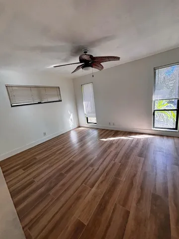 a view of empty room with wooden floor