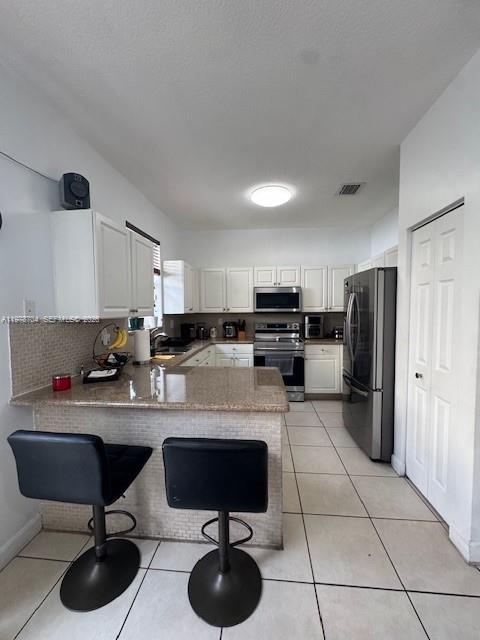 12923 Southwest 135th Terrace Miami, FL 33186 - Photo 14 of 71 a kitchen with stainless steel appliances kitchen island granite countertop a sink and cabinets