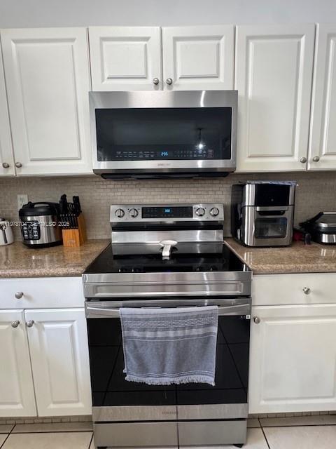 12923 Southwest 135th Terrace Miami, FL 33186 - Photo 16 of 71 a stove top oven sitting inside of a kitchen and white cabinets
