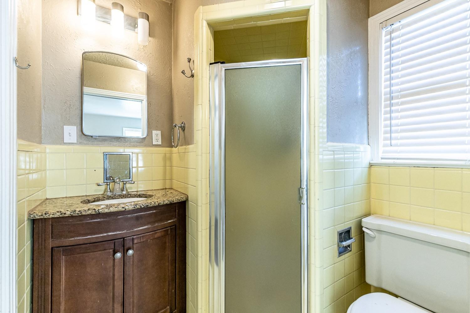 3708 27th Street Lubbock, TX 79410 - Photo 15 of 23 a bathroom with a granite countertop sink toilet and mirror