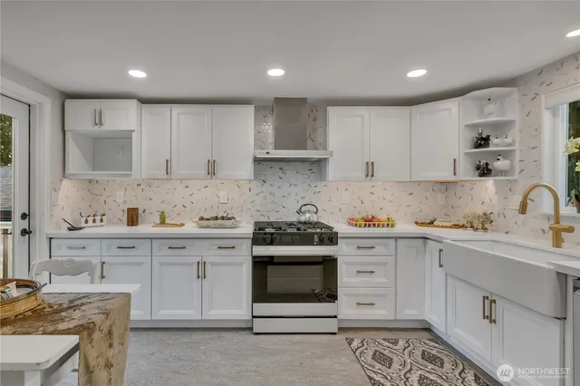 a kitchen with stainless steel appliances granite countertop a stove and white cabinets