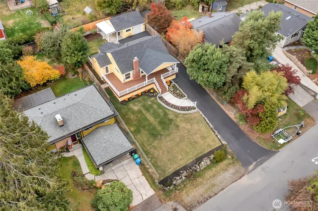 an aerial view of a house with a yard and lake view
