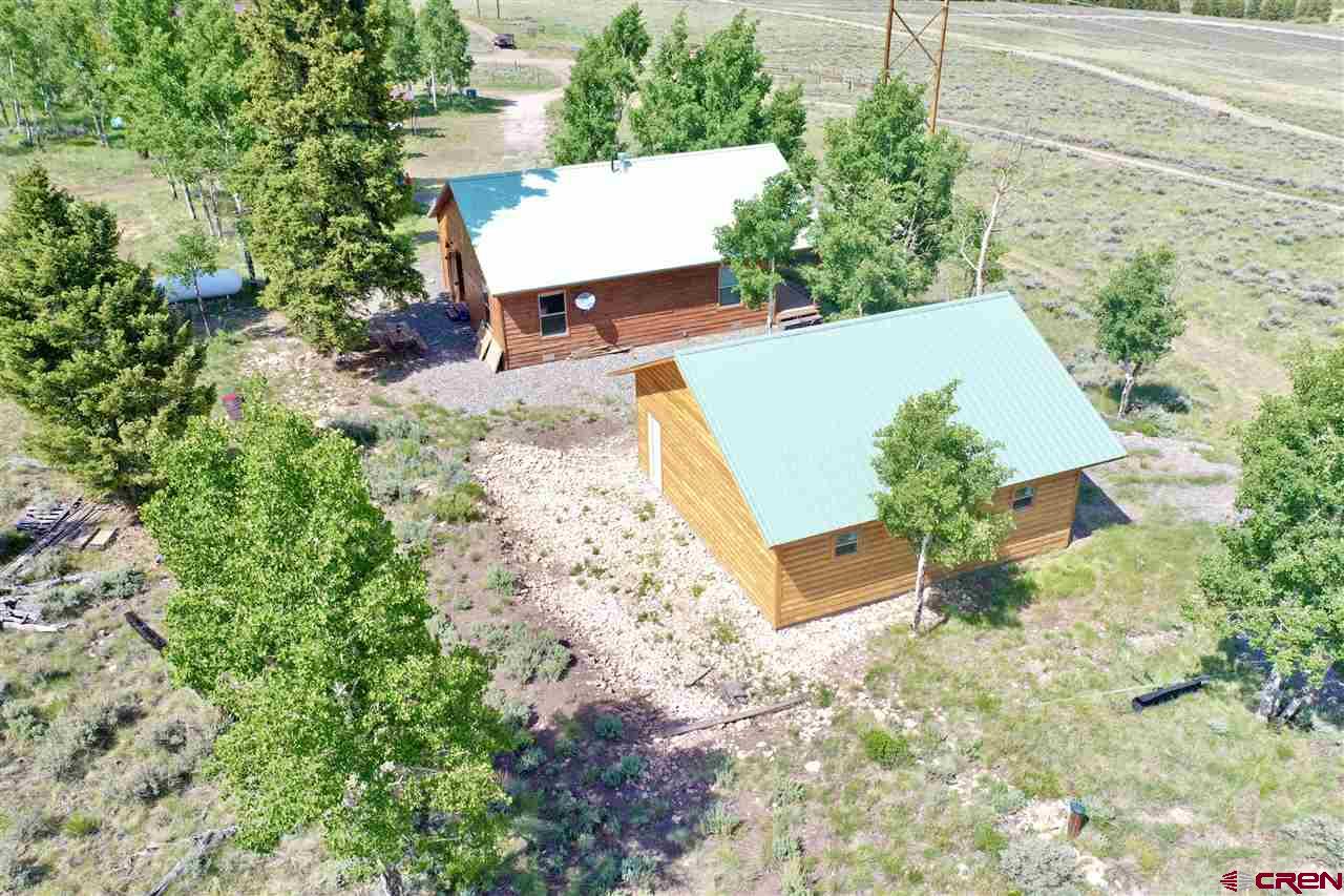 1019 Uncompahgre Drive Powderhorn, CO 81243 - Photo 13 of 33 an aerial view of a house with a yard and trees all around