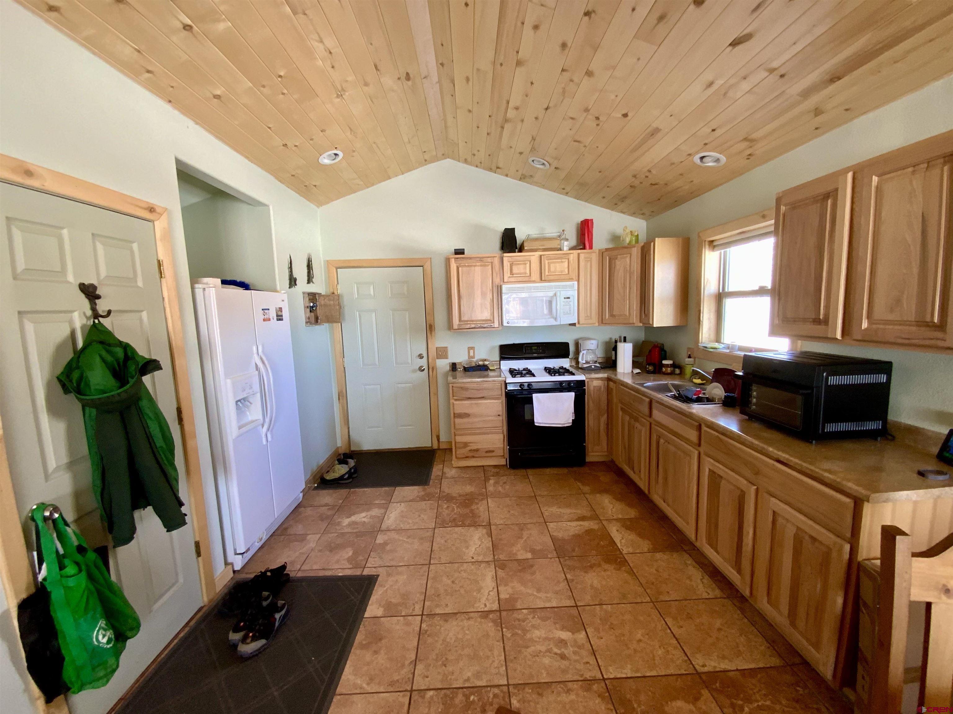1019 Uncompahgre Drive Powderhorn, CO 81243 - Photo 17 of 33 a kitchen with stainless steel appliances a refrigerator a sink a stove top oven a counter space and cabinets
