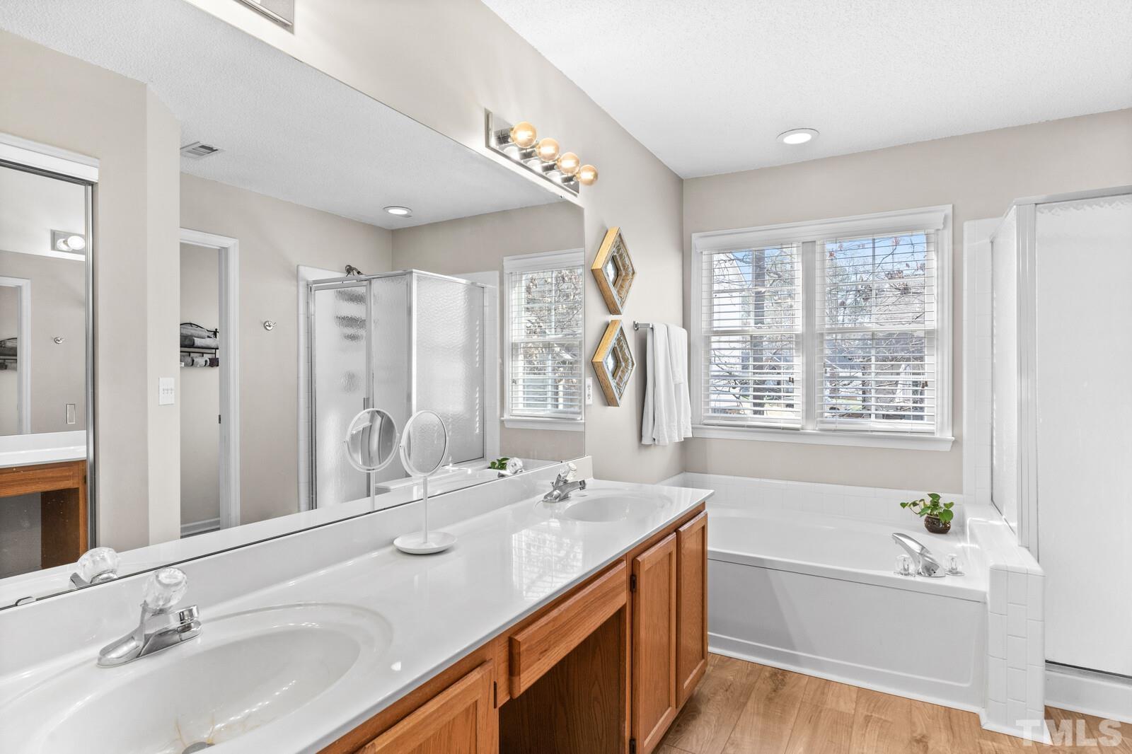 12104 Amoretto Way Raleigh, NC 27613 - Photo 14 of 21 a bathroom with a tub double sink window and mirror