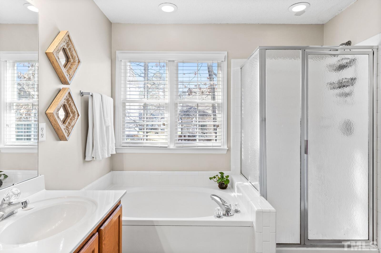 12104 Amoretto Way Raleigh, NC 27613 - Photo 15 of 21 a bathroom with a bathtub and a sink