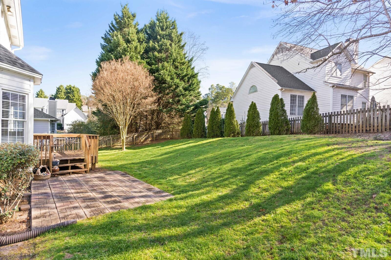12104 Amoretto Way Raleigh, NC 27613 - Photo 20 of 21 a view of a white house in a big yard with a fountain plants and large trees