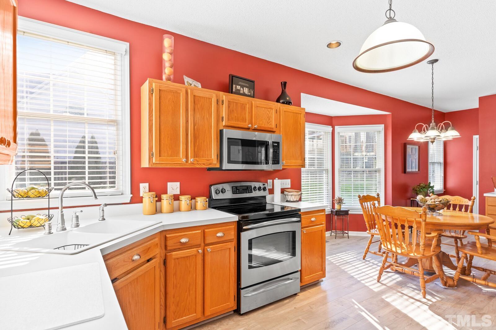 12104 Amoretto Way Raleigh, NC 27613 - Photo 8 of 21 a kitchen with a sink stove and chairs