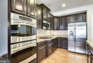 a kitchen with stainless steel appliances granite countertop a refrigerator and a stove top oven