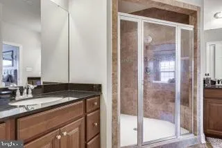 a bathroom with a granite countertop sink and mirror