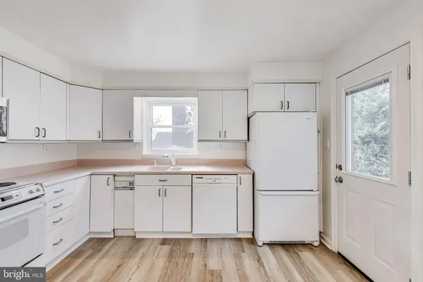 a view of a kitchen with a sink dishwasher and wooden floor