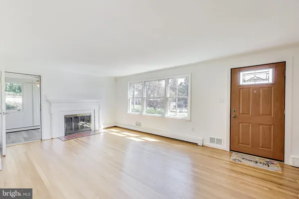wooden floor fireplace and windows in an empty room