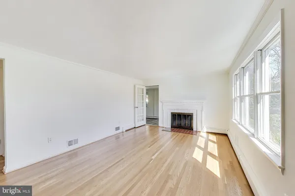a view of a hallway with wooden floor and front door