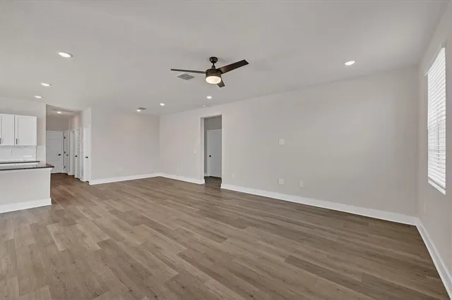 a kitchen with stainless steel appliances granite countertop a sink a stove a refrigerator and island with wooden floor