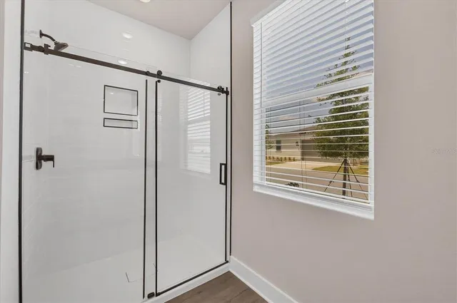 an empty room with a window and ceiling fan