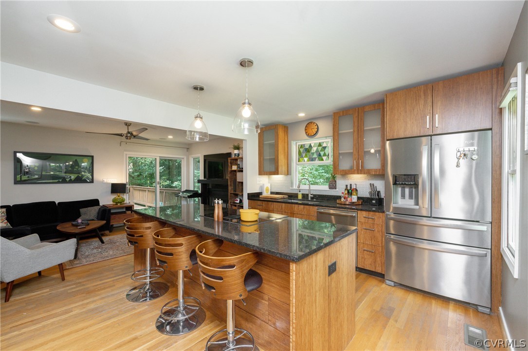 4330 Waumsetta Road Richmond, VA 23235 - Photo 10 of 35 a kitchen with stainless steel appliances granite countertop a refrigerator a stove a sink a dining table and chairs with wooden floor