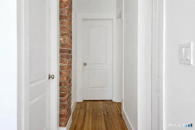 a view of a hallway with wooden floor