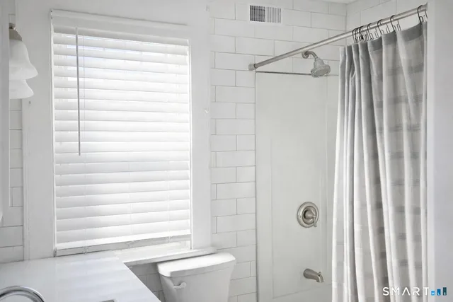 a bathroom with a shower and a window