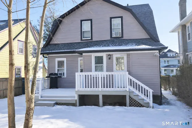 a view of a house with a deck and furniture