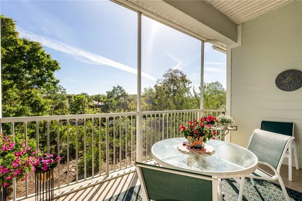 a balcony with wooden floor table and chairs