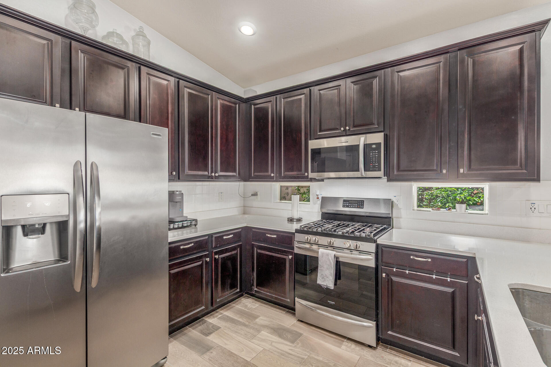 4136 West Palace Station Road New River, AZ 85087 - Photo 6 of 19 a kitchen with granite countertop stainless steel appliances and wooden cabinets