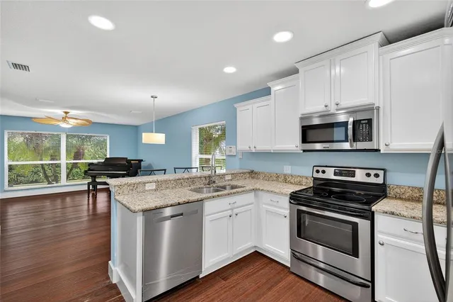 a kitchen with granite countertop a sink and a stove
