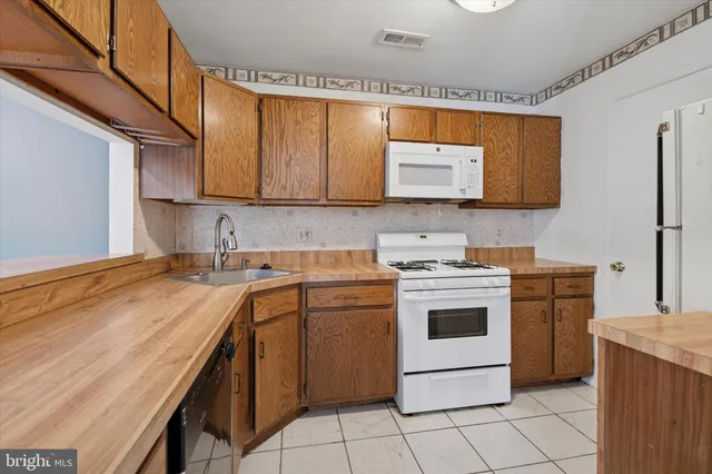 a kitchen with a stove sink and cabinets