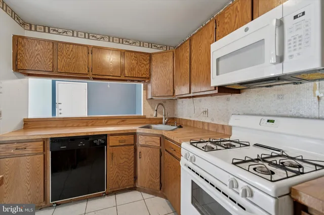a kitchen with granite countertop a stove sink and cabinets
