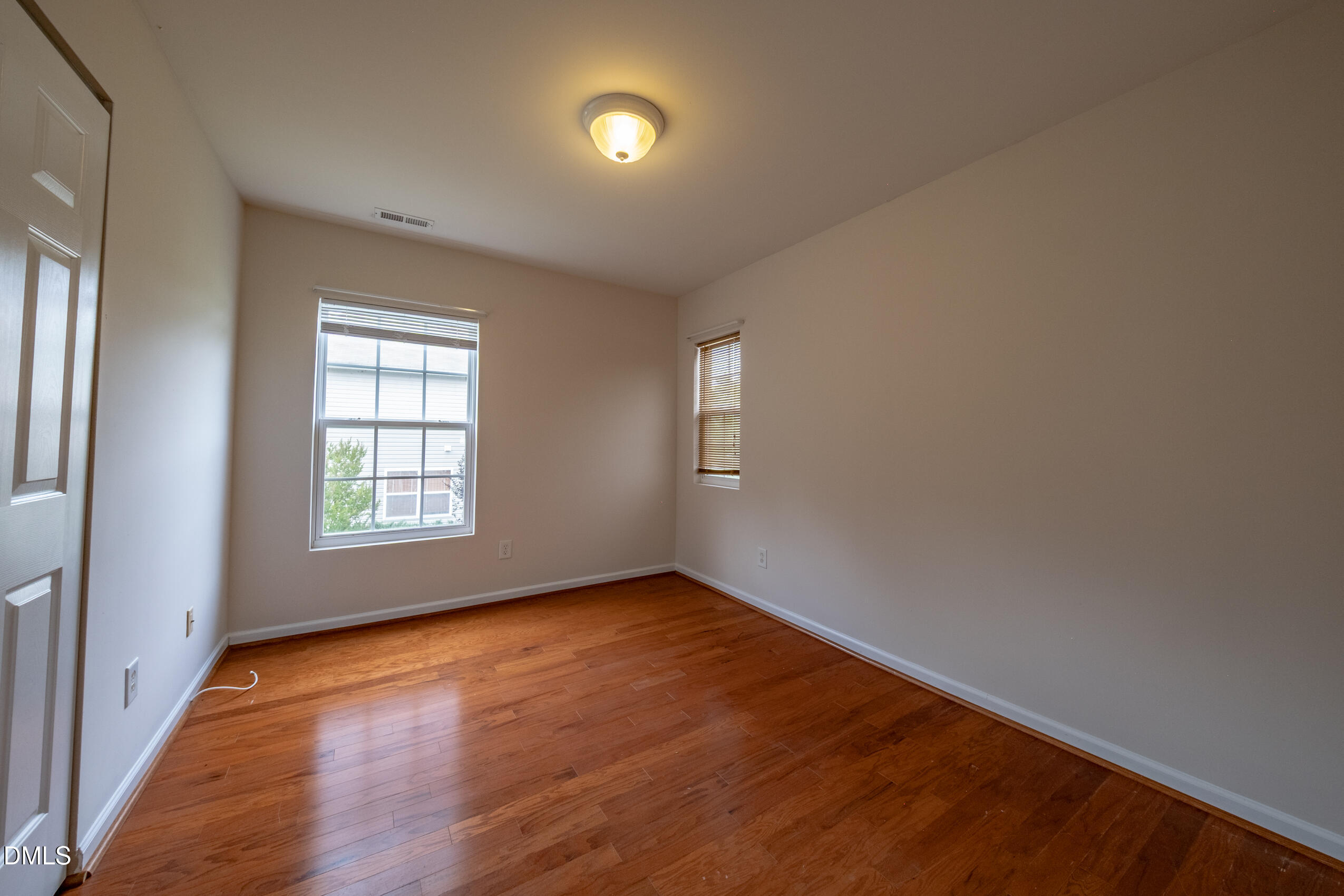 719 Obsidian Way Durham, NC 27703 - Photo 24 of 41 an empty room with wooden floor and windows