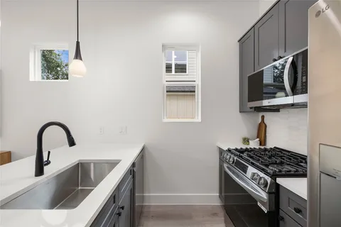 a kitchen with stainless steel appliances granite countertop a sink a stove and microwave