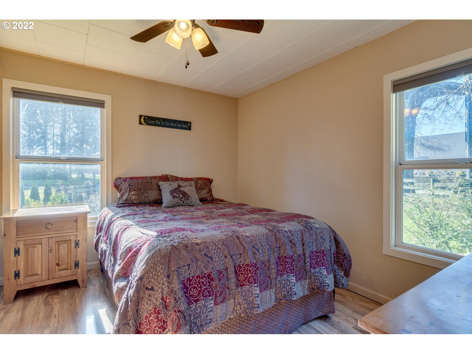 18876 Butteville Road Northeast Aurora, OR 97002 - Photo 7 of 32 a bedroom with a bed a chandelier and a window