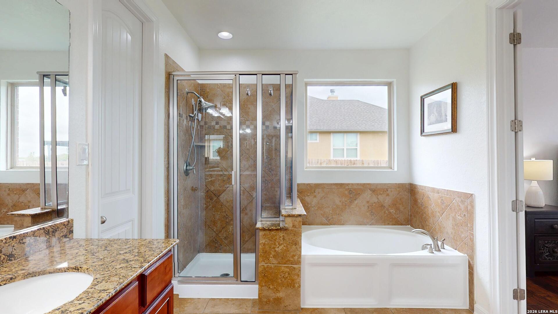 10111 Shallow Bank Converse, TX 78109 - Photo 47 of 65 a bathroom with a granite countertop tub sink and glass door