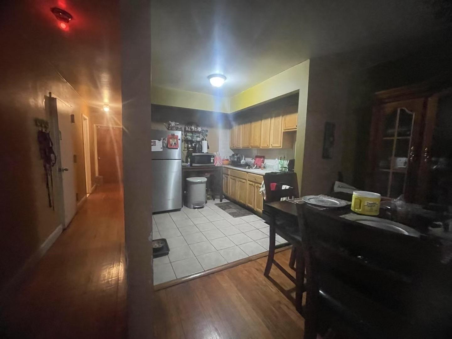 57-25 Waldron Street Queens, NY 11368 - Photo 6 of 9 Kitchen featuring light brown cabinetry, sink, stainless steel appliances, and light hardwood / wood-style floors