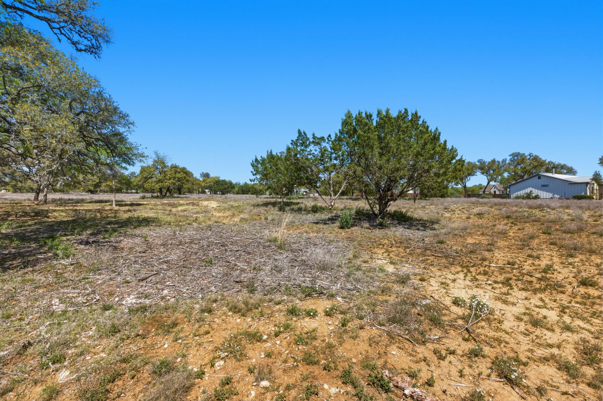 268 Kinnikinik Loop Austin, TX 78737 - Photo 27 of 32 a view of a field with trees in background